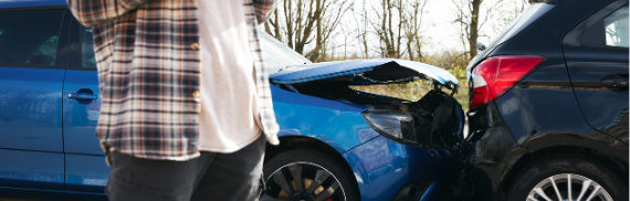 Motorista observa dois carros após colisão na pista
