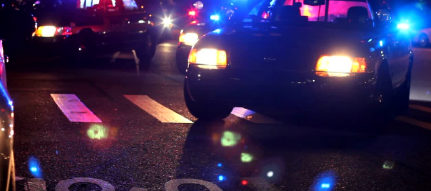 Giroflex de viatura policial iluminando a via à noite